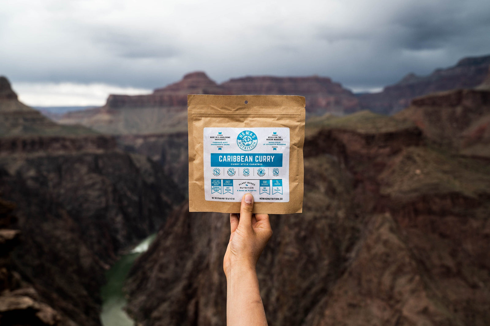 Nomad Nutrition Caribbean Curry, vegan dehydrated adventure, gluten-free, plant-based meal, overlooking the canyon valley at a national park.
