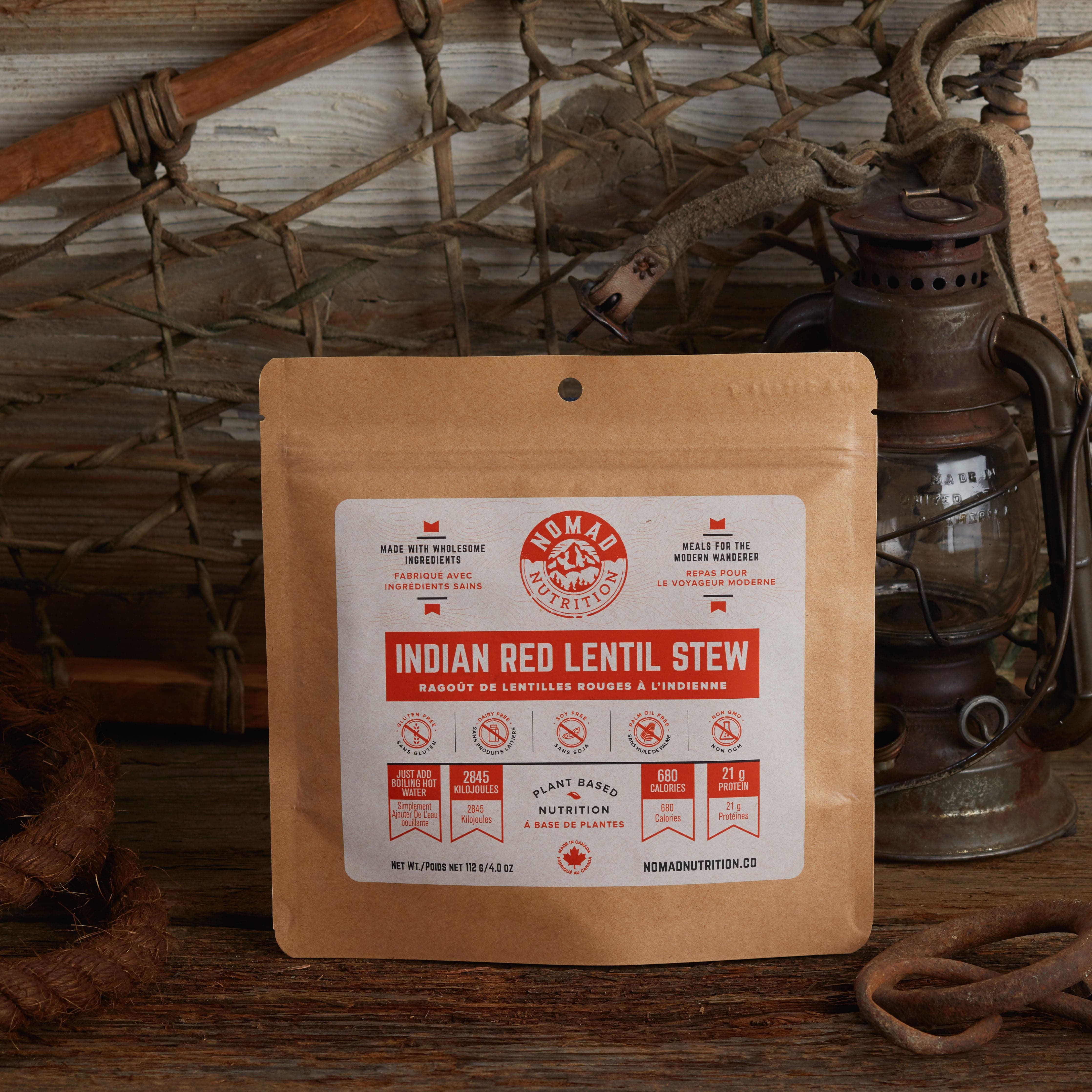 Nomad Nutrition Indian Red Lentil Stew 112g meal size with outdoor equipments on table top.