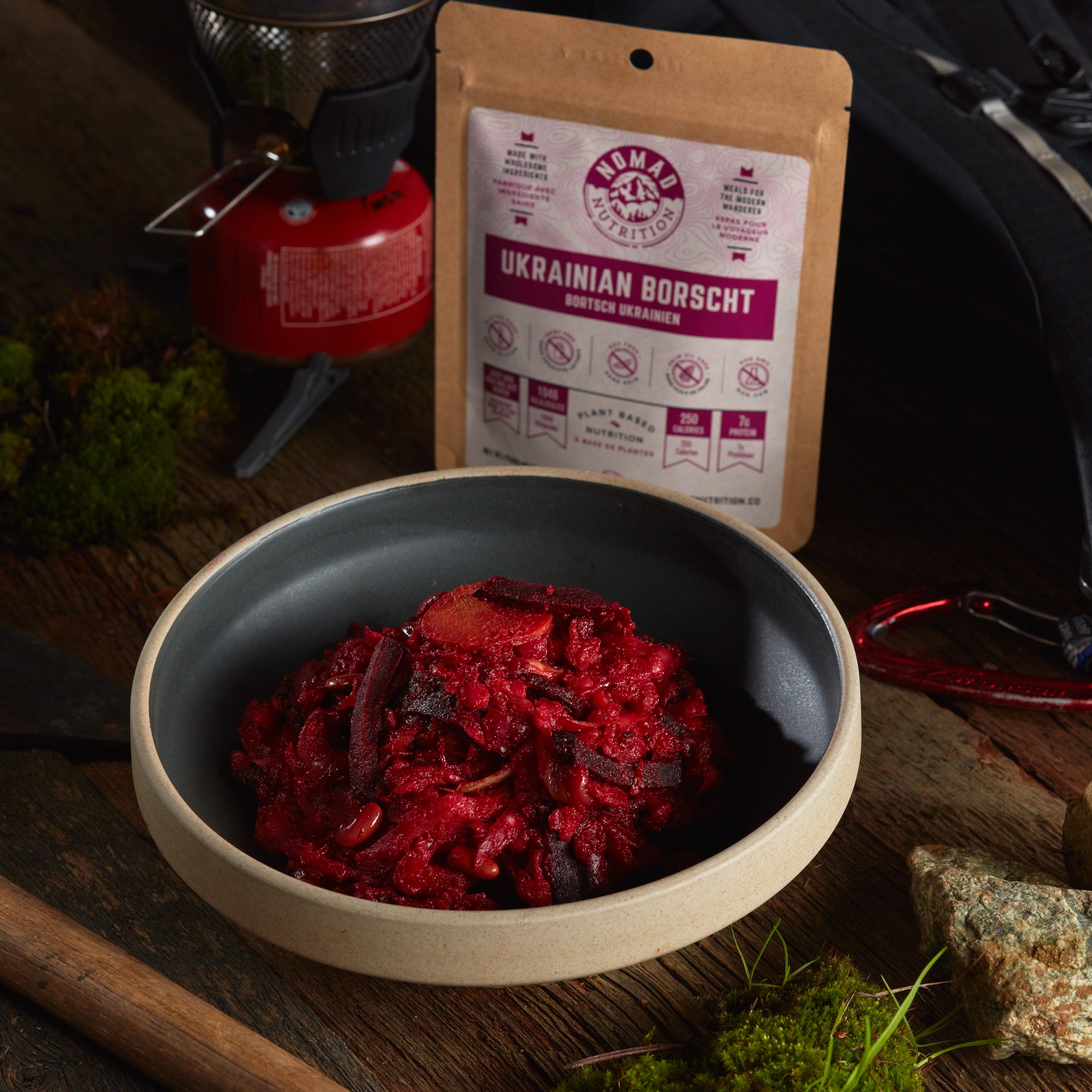 Rehydrated Nomad Nutrition Ukrainian Borscht in a bowl with 56g meal size on table top outdoors. No additional cooking required.