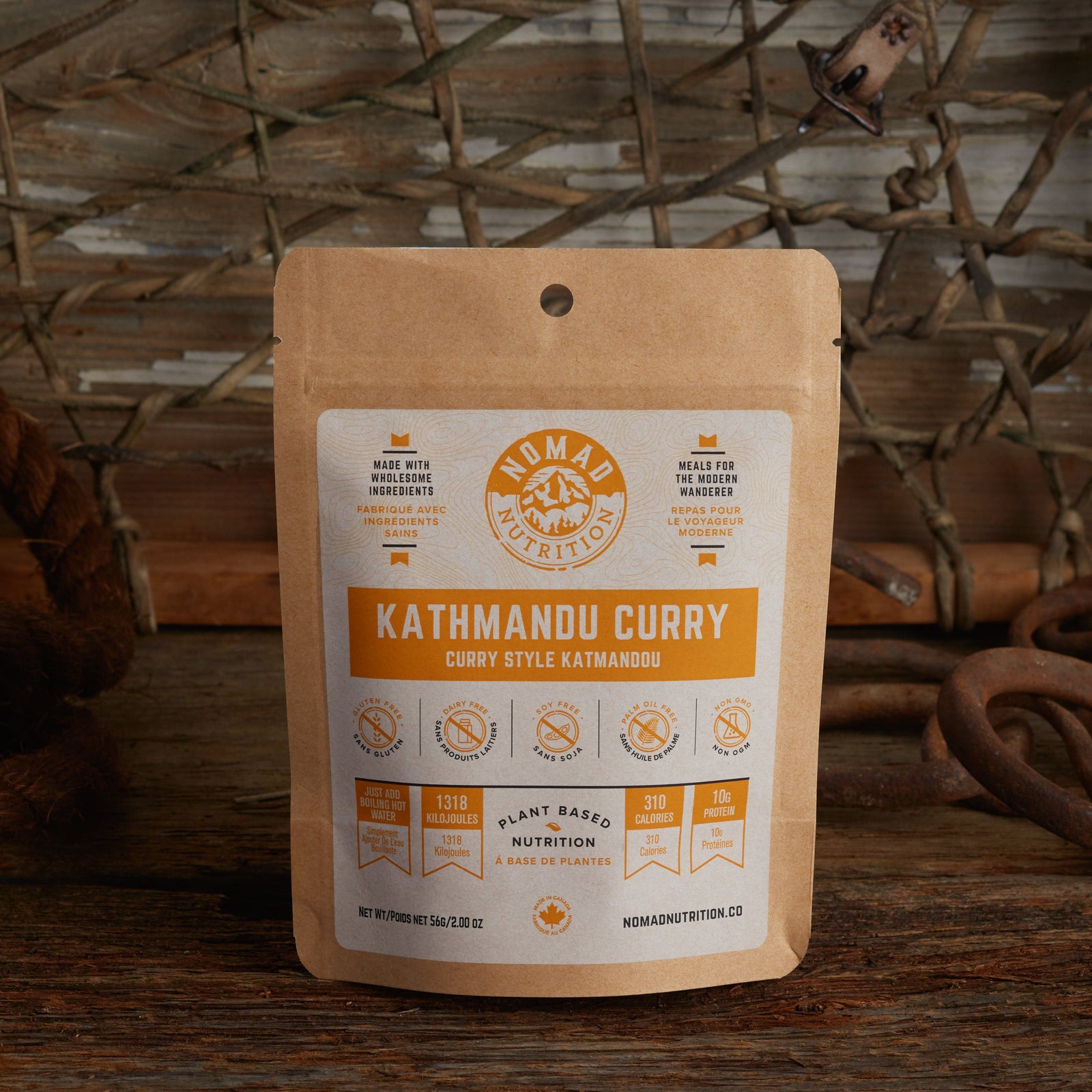 Nomad Nutrition Kathmandu Curry 56g snack size with outdoor equipments on table top.