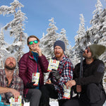 4 people posing with Nomad Nutrition's Chewy Banana Bites while enjoying the dehydrated banana pieces outdoors in the winter. 