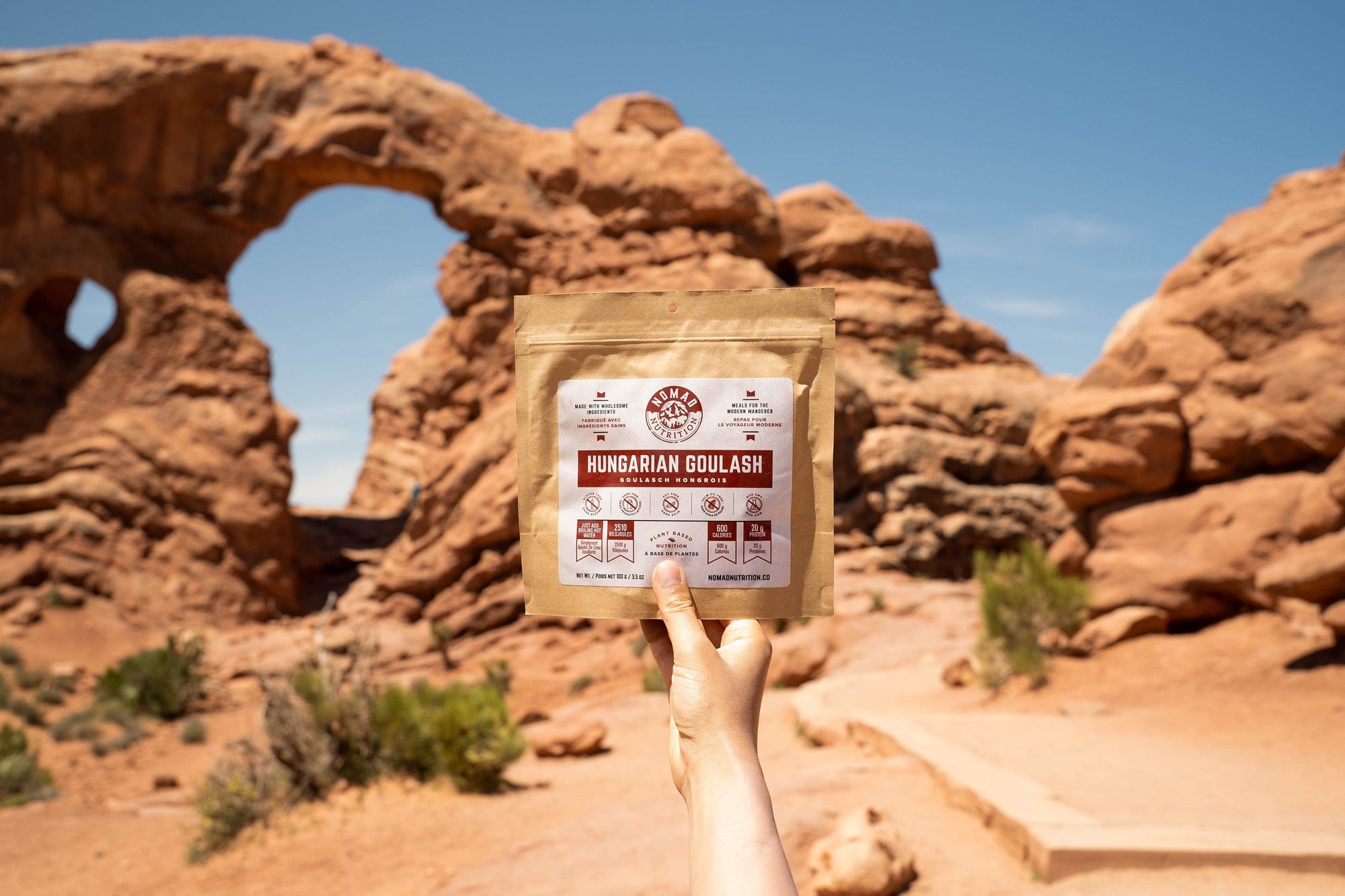 Nomad Nutrition Hungarian Goulash (112g/ 4oz) dehydrated vegan adventure plant-based, gluten-free meal at Arches National Park with canyons visible in the background.