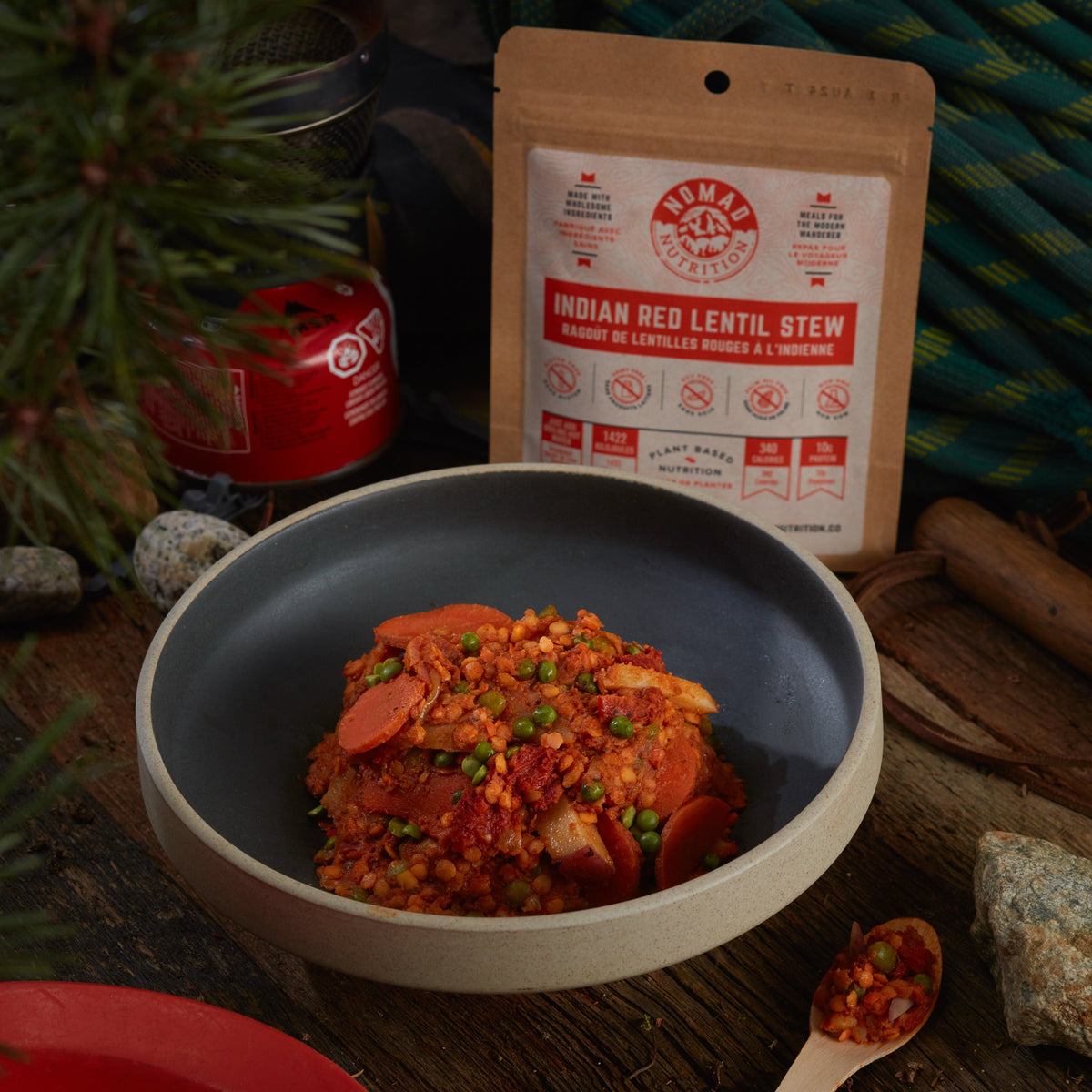 Rehydrated Nomad Nutrition Indian Red Lentil Stew in a bowl with 56g snack size on table top outdoors. No additional cooking required. Picture for reference only.