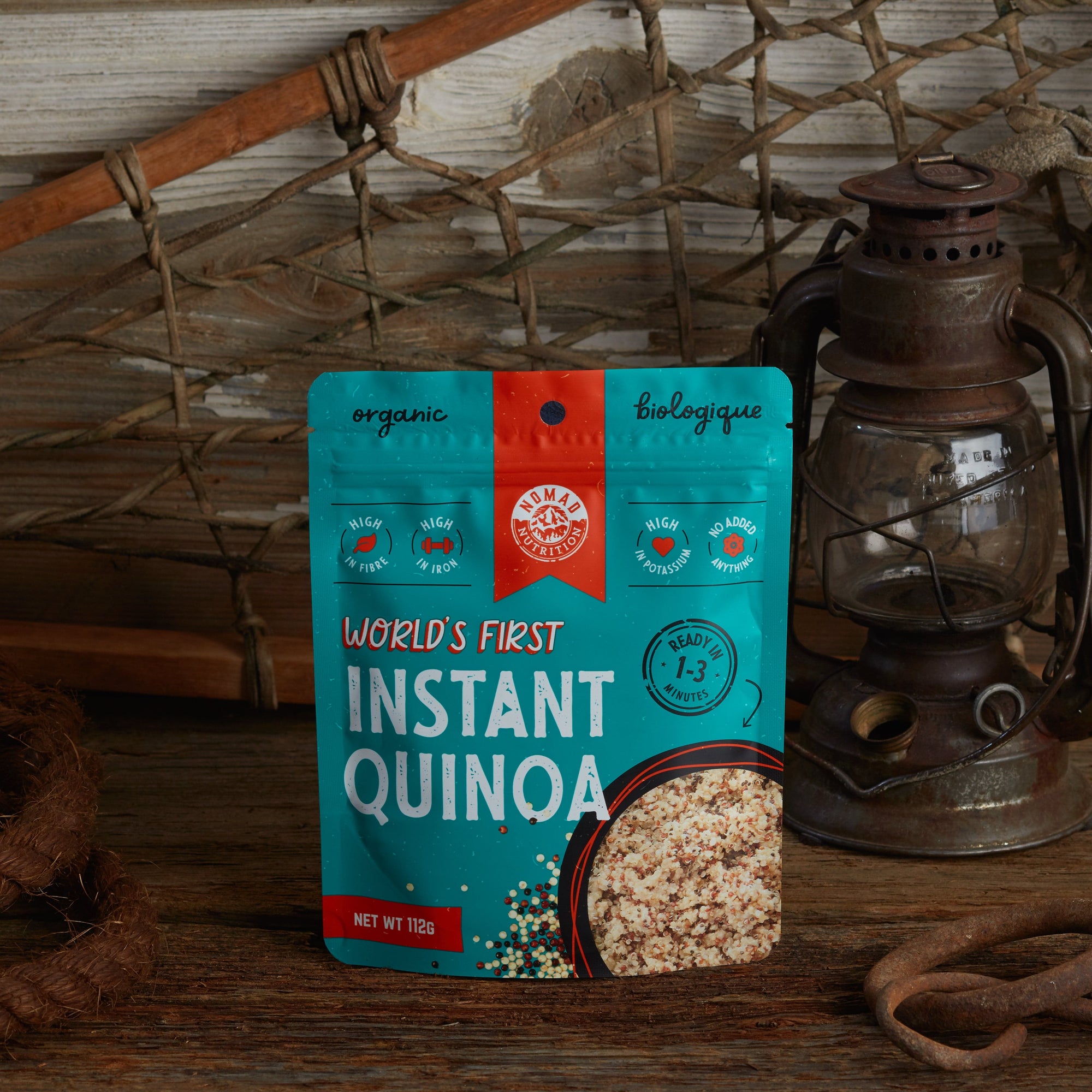 Nomad Nutrition Instant Quinoa 112g meal size with outdoor equipments on table top.