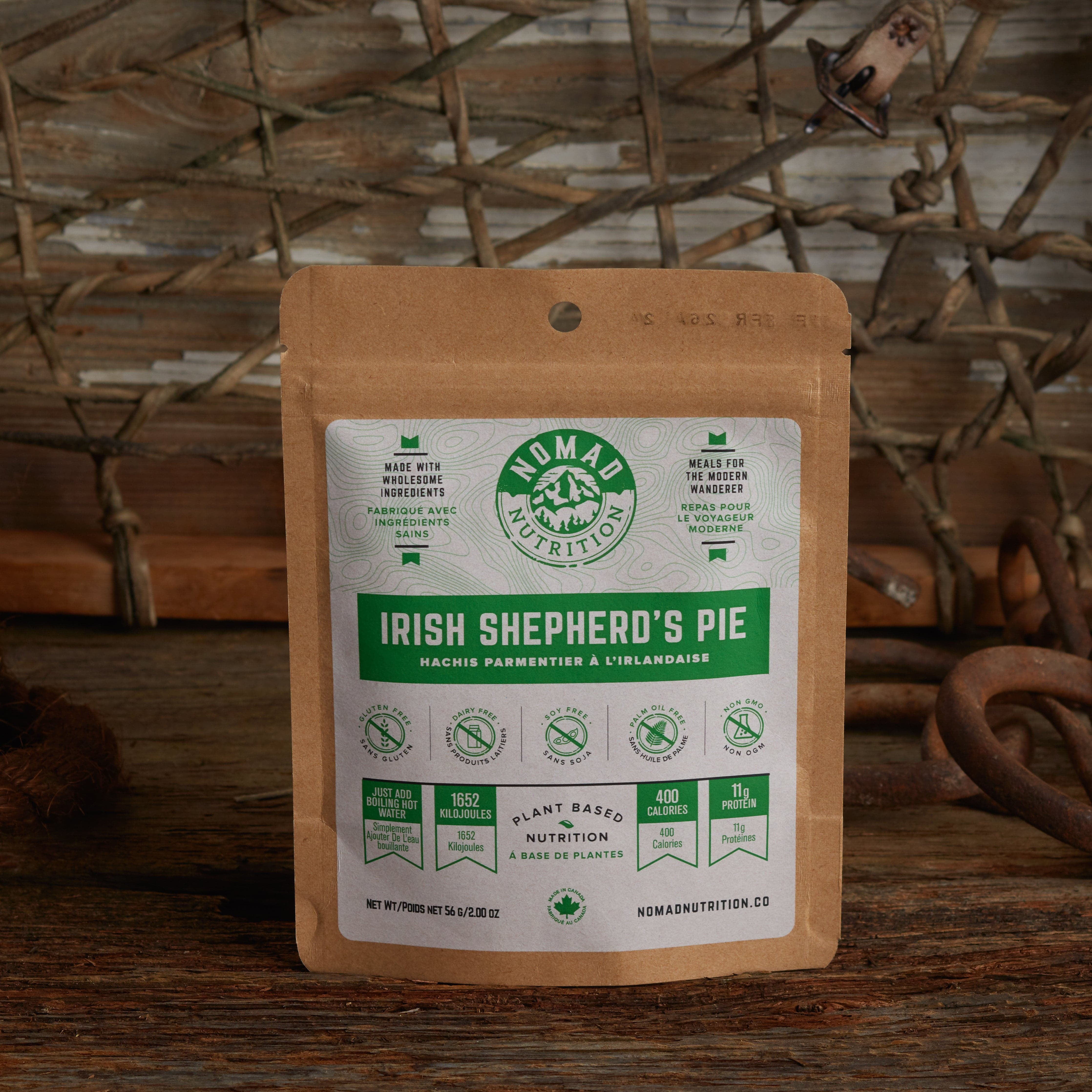 Nomad Nutrition Irish Shepherd's Pie 56g snack size with outdoor equipments on table top.