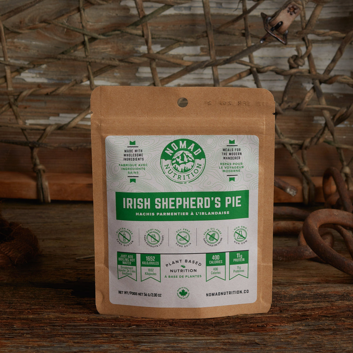 Nomad Nutrition Irish Shepherd's Pie 56g snack size with outdoor equipments on table top.