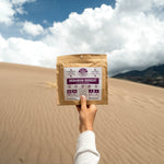 Nomad Nutrition Ukrainian Borscht meal. Held up against scenic views of the desert at a national park. 