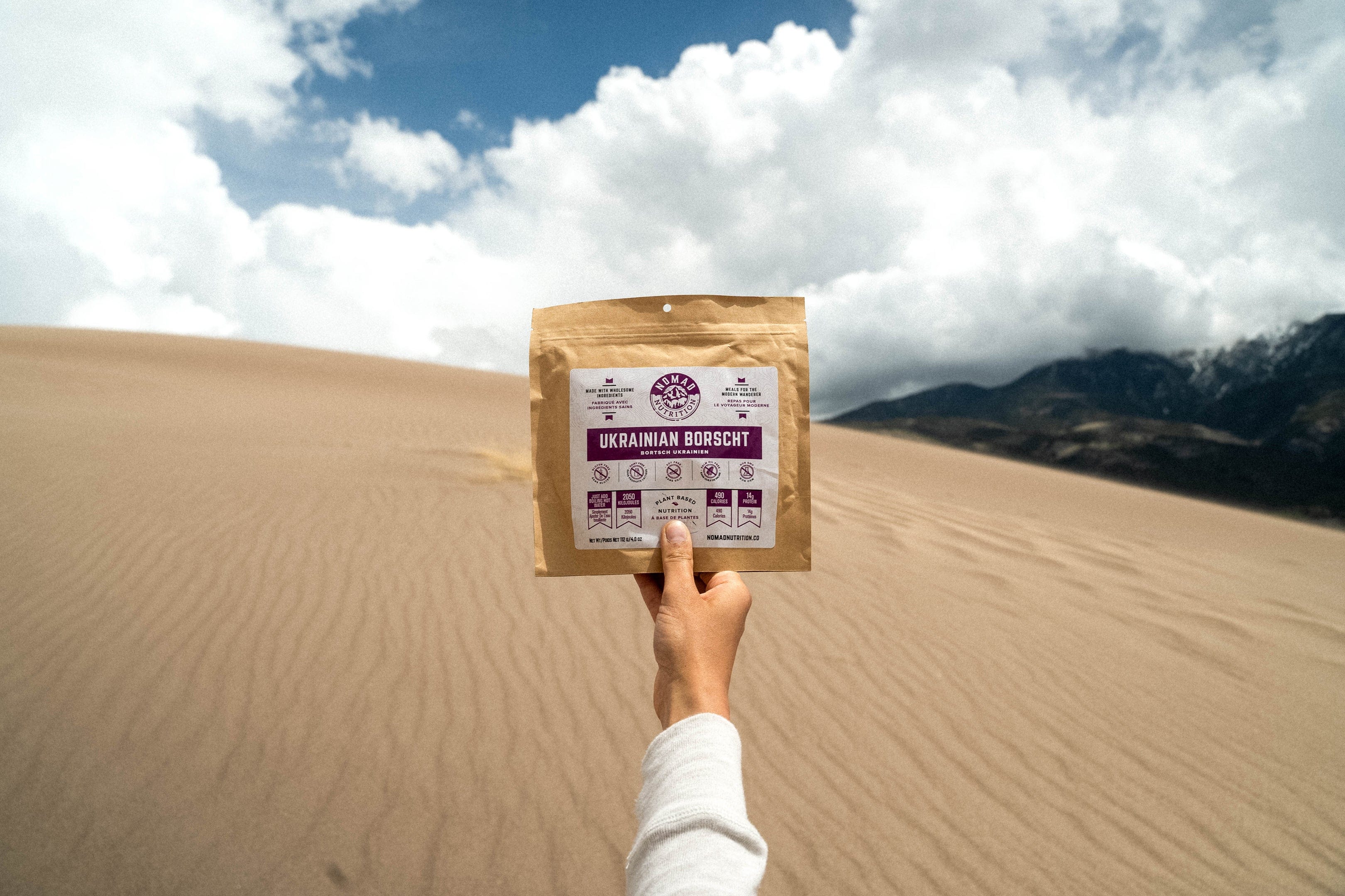 Nomad Nutrition Ukrainian Borscht meal. Held up against scenic views of the desert at a national park. 
