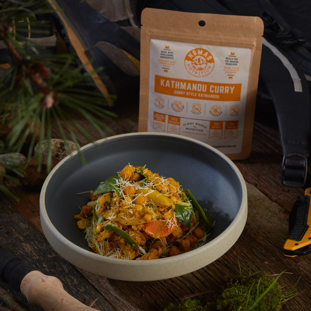 Rehydrated Nomad Nutrition Kathmandu Curry in a bowl with 56g snack  size on table top outdoors. No additional cooking required. 