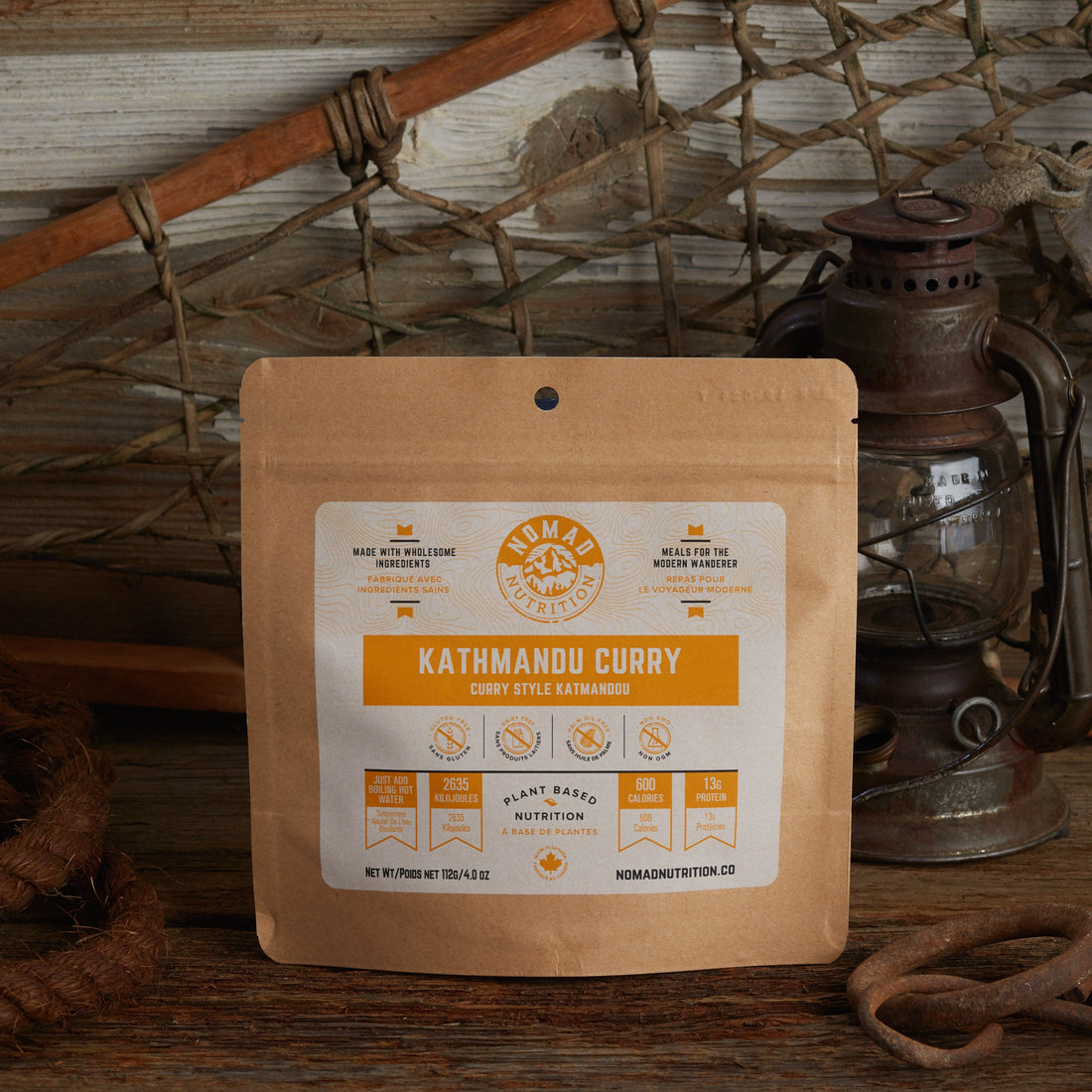 Nomad Nutrition Kathmandu Curry 112g meal size with outdoor equipments on table top.